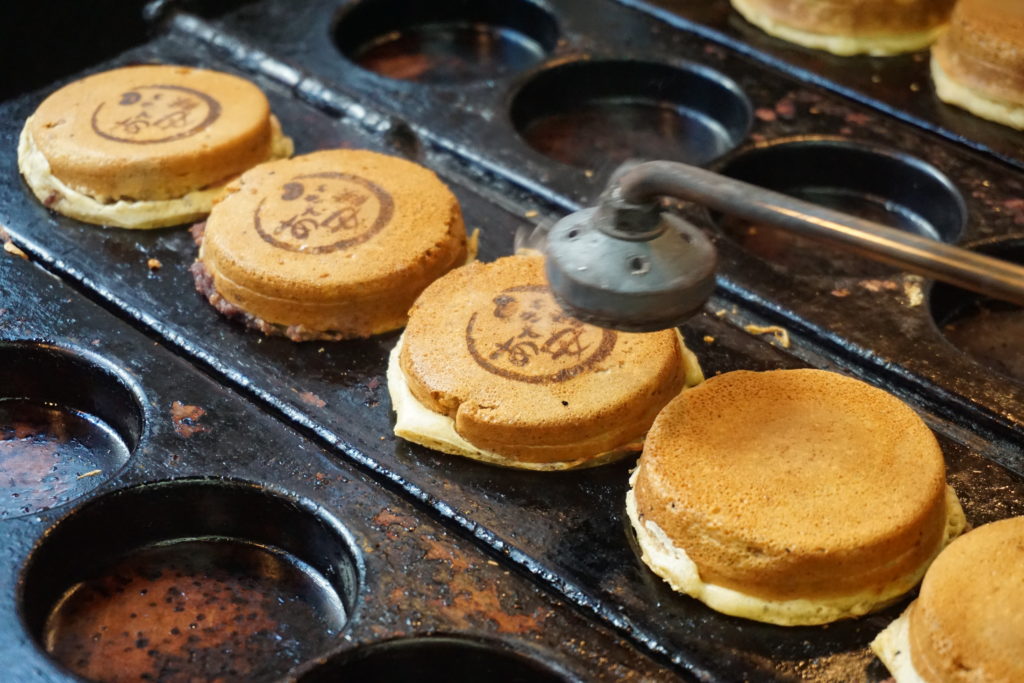Imagawa-yaki lined up in their special griddle. Branded with Adzukiya Andō’s mark.